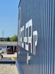 Réalisation de décoration de bâtiment et pose d'enseigne par l'équipe Le point com'
